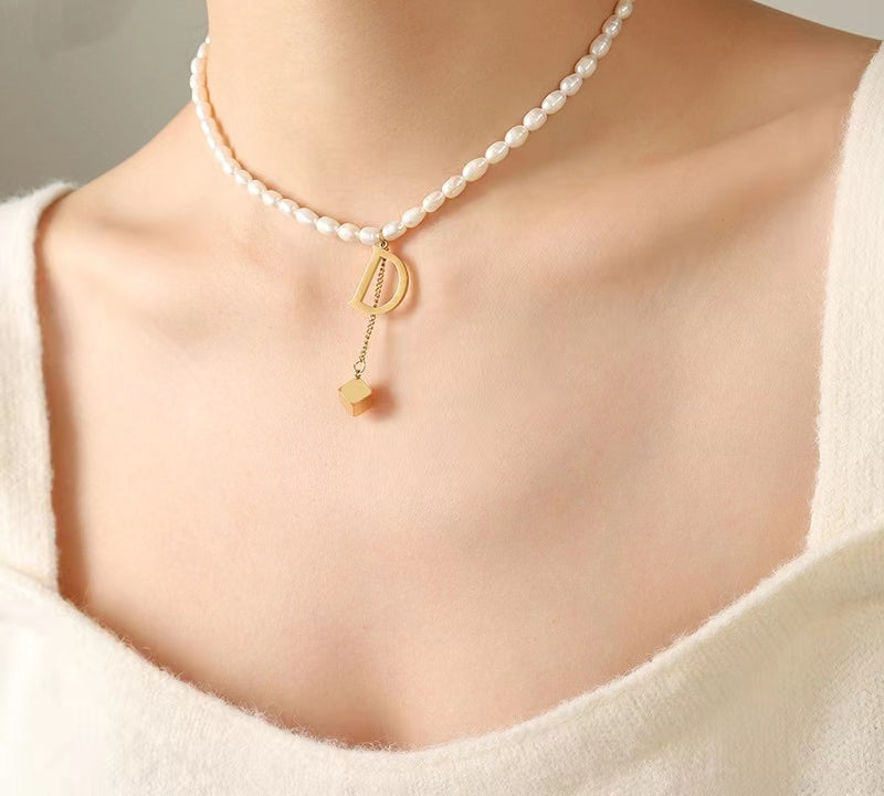 Collar D de acero y titanio con perla de agua dulce genuina