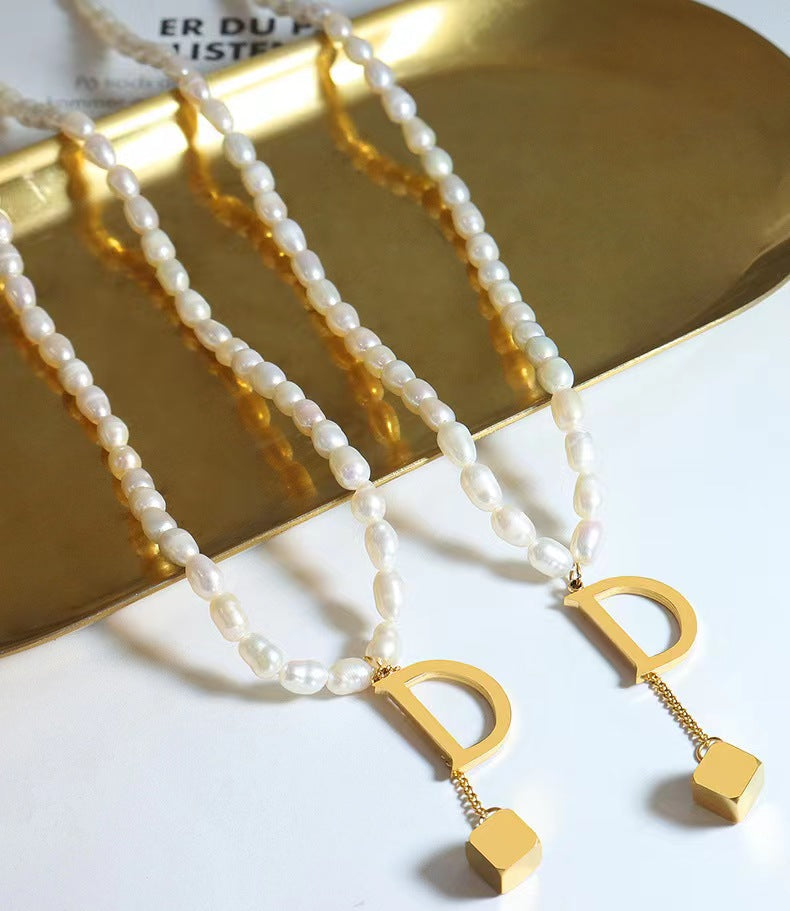 Collar D de acero y titanio con perla de agua dulce genuina