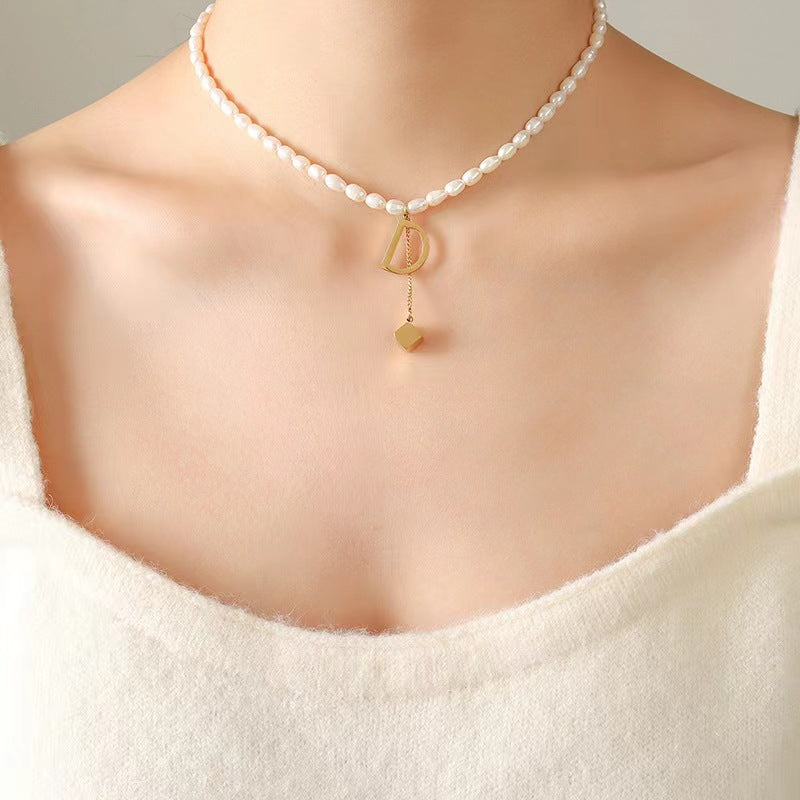 Collar D de acero y titanio con perla de agua dulce genuina